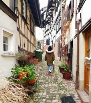 A person walking between houses through the city