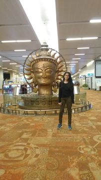 Neha in front of a golden statue
