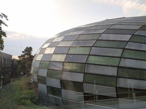 Exterior view of an oval building with glass walls