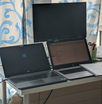 A home office setup with several laptops and screens.