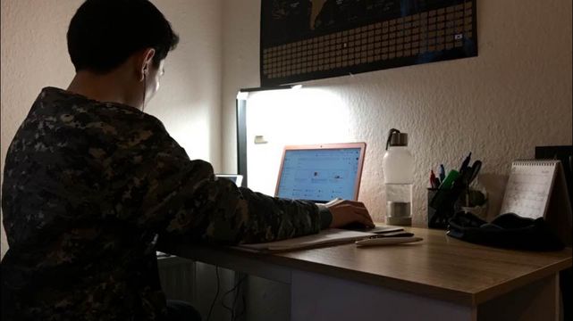 Jun works on a laptop.