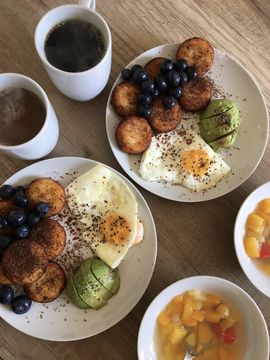 Delicious breakfast with coffee, egg, avocado, sandwiches and fruit.