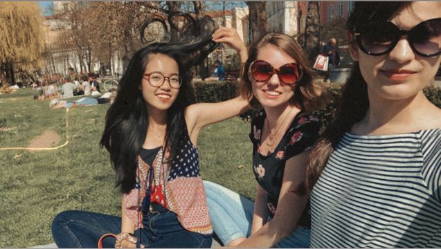 Anh is picknikcing with two friends on the university meadow