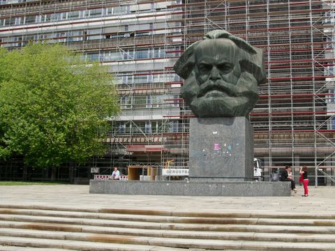 The Karl Marx statue in the center of Chemnitz, with passersby and students leaning against its pedestal. © Brüggemann/DAAD