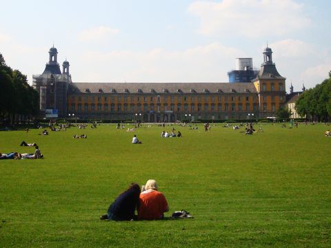 Students relax on the lawn of the Court Garden in front of Bonn University. © Bauz/DAAD