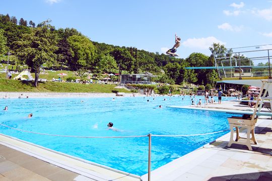 View of the Spiesel outdoor pool in Aalen with many young people and students in the water. © City of Aalen