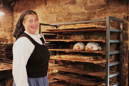 Eine Frau backt Brot wie vor 100 Jahren