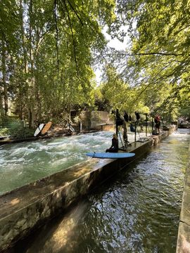 People take part in a surfing course at the Isar river