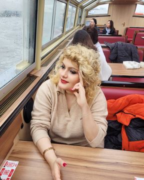 Lilit is sitting at the window of a small tourist boat, taking a tour of the canals of Amsterdam.