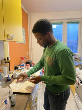 Ayo in his shared kitchen, baking.