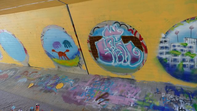 In the picture you can see the finished graffiti of Lilit and her fellow students: a kind of portholes on a yellow background, through which you can see abstract underwater scenes.