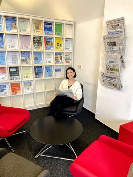 Jinmeng sitzt in der Bücherei und liest Magazine