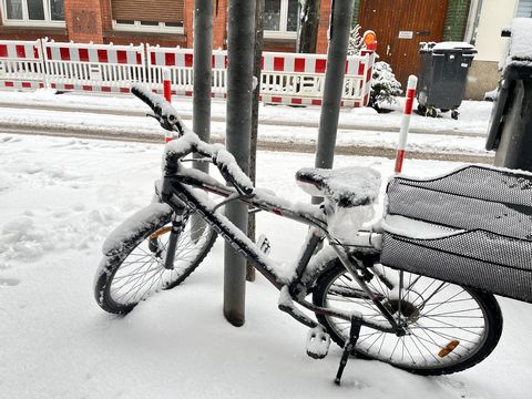 Snow all over a bicycle beside a road