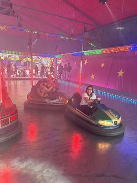 Elisa enjoys a ride on the bumper cars with her friends.