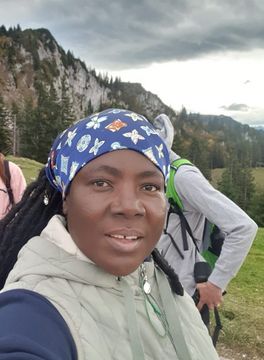 Selfie of Doris in hiking gear. Mountains in the background.