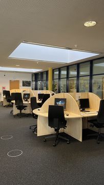 Many computer workstations are available to students, separated from each other in a slightly different space. Skylights provide natural light, which makes working and learning more pleasant.