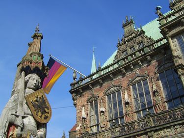 Die Roland-Statue neben dem Bremer Rathaus mit der Deutschland-Flagge. © Bremer Touristik-Zentrale
